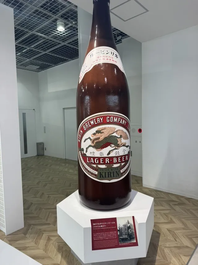 A giant Kirin lager beer bottle on a white plinth inside the Kirin Beer Factory