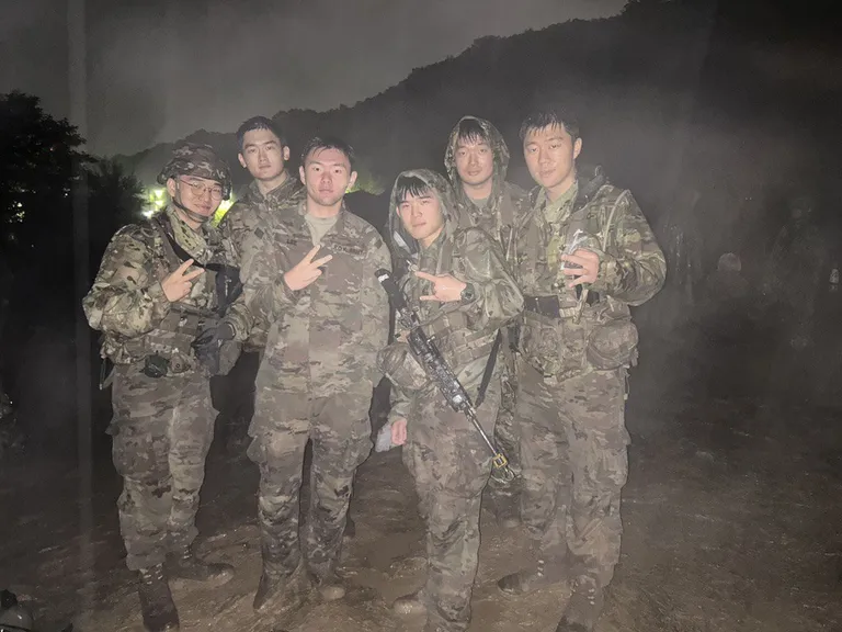 Doheon Kim and five fellow soldiers posing together at night in the mist
